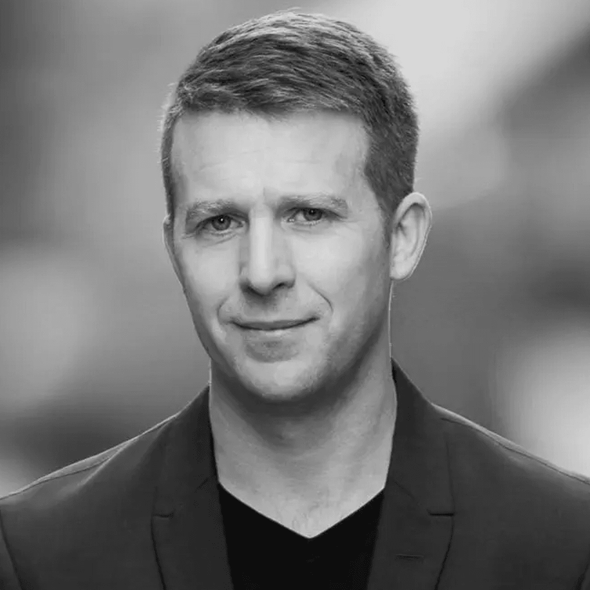 Man I 40 års åldern. Kortklippt går, klädd i t-shirt och kavaj.