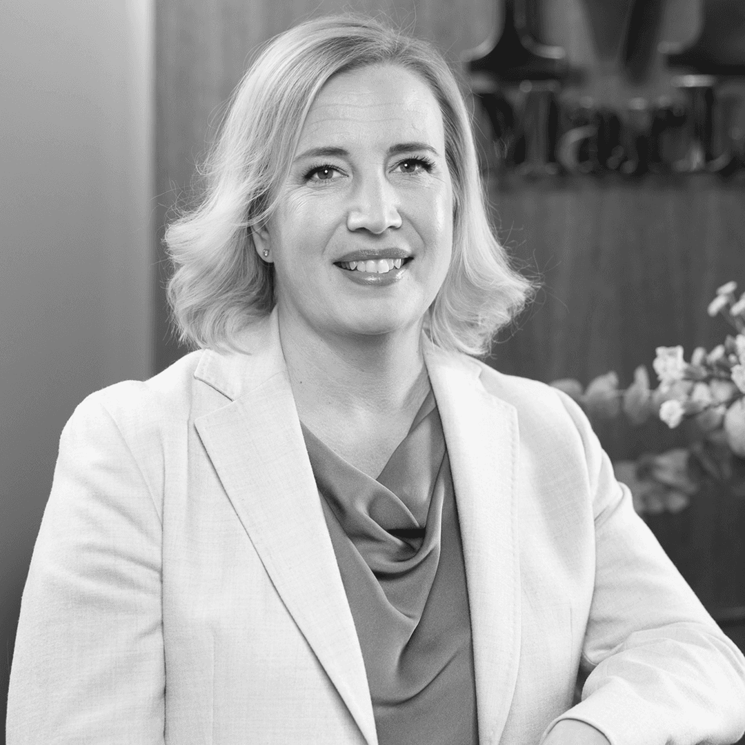 Kvinna med lockad page. Ler och tittar in i kameran.