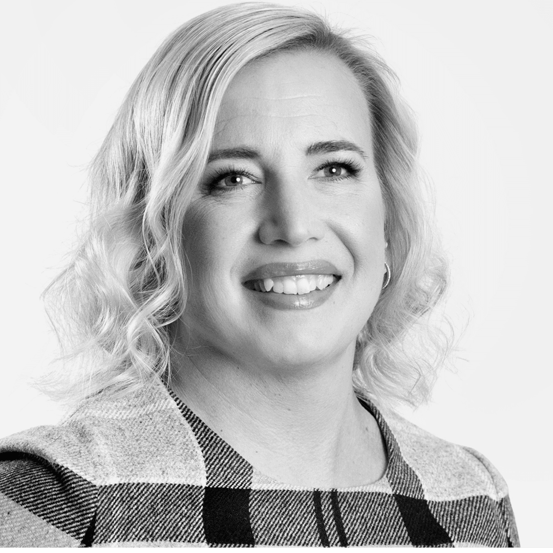 Kvinna med lockad page. Ler och tittar in i kameran.