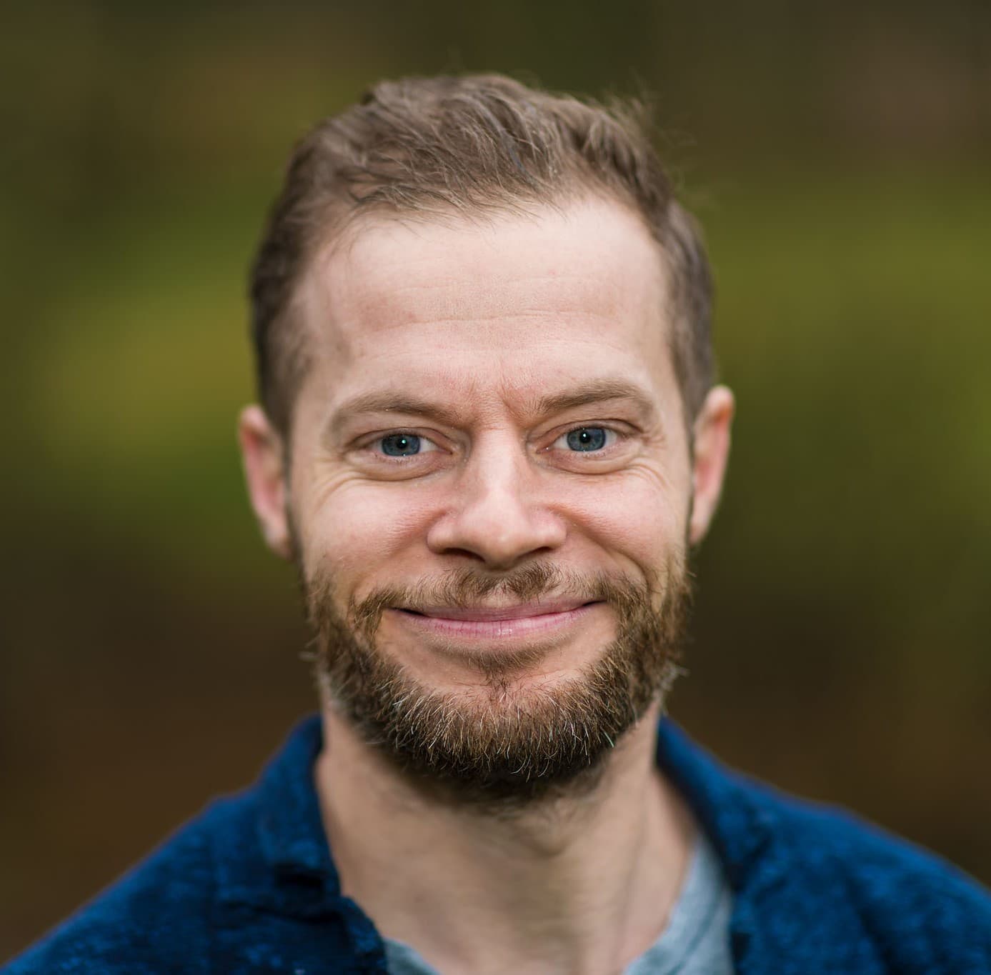 Leende medelålders vit man med skägg och kort hår