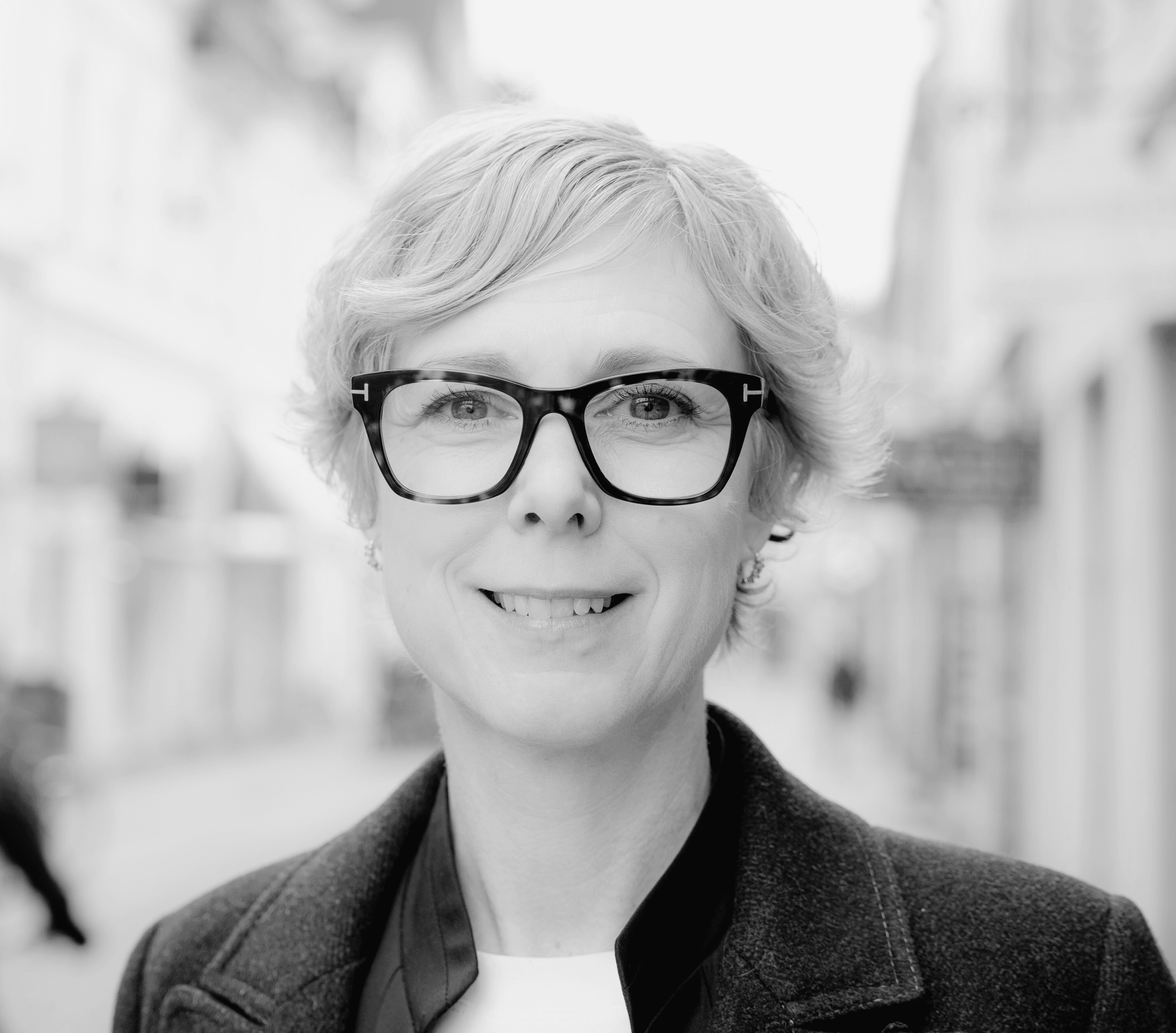 kortklippt blond kvinna med svarta glasögon