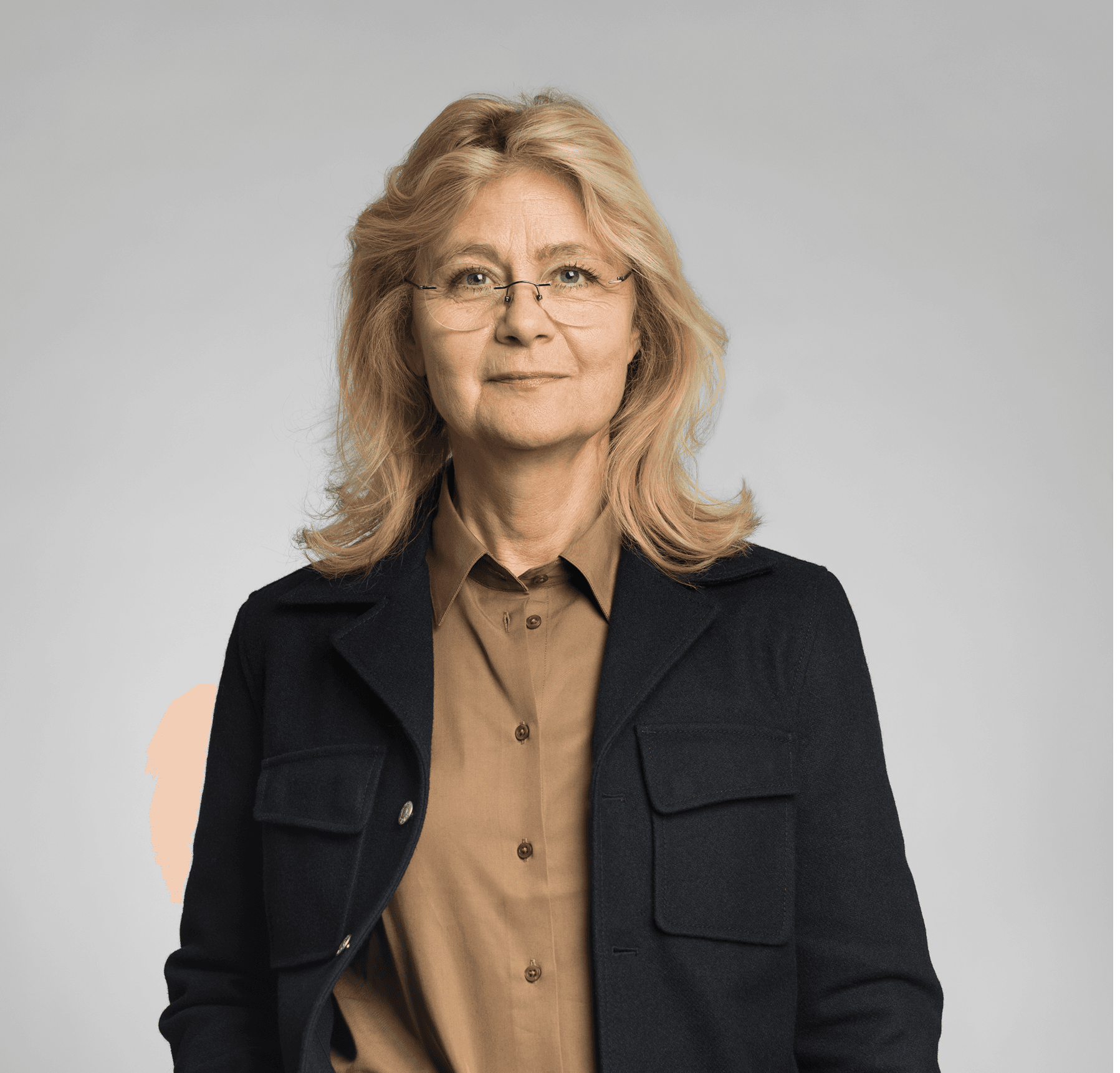 Blond kvinna med axellångt hår och glasögon tittar in mot kameran