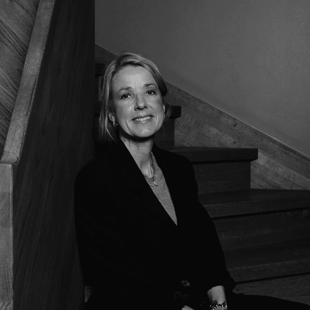 Kvinna med blont hår och svart kavaj.