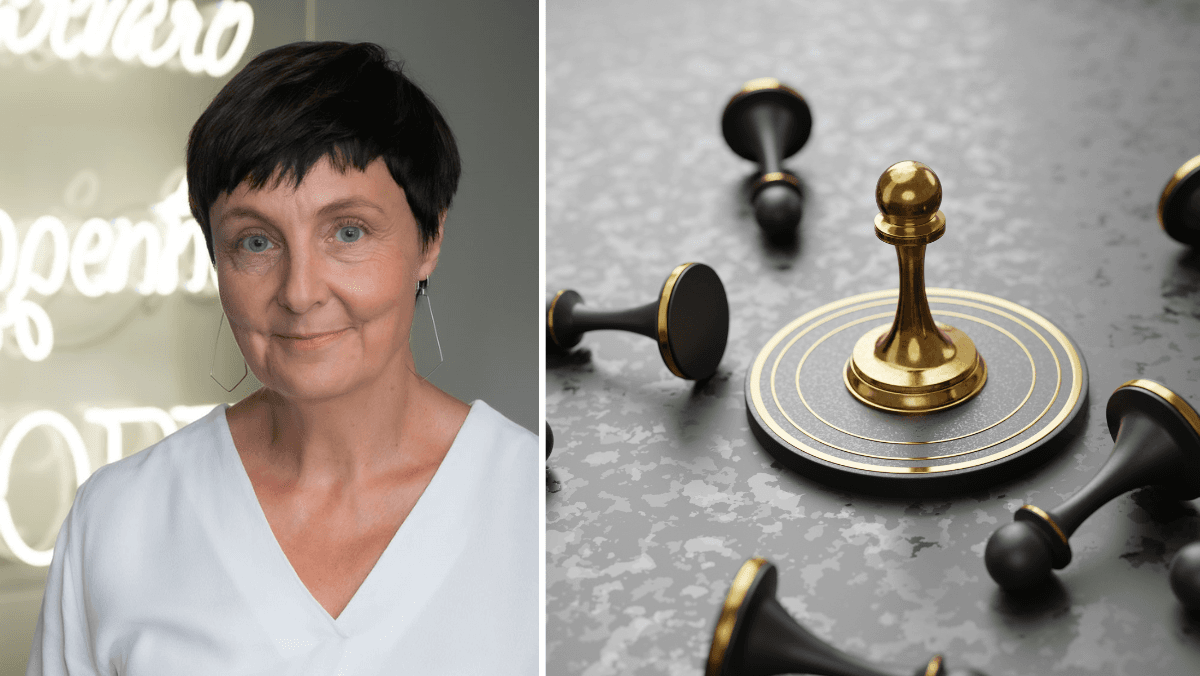 Kvinna poserar för foto tillsammans med schackpjäser.