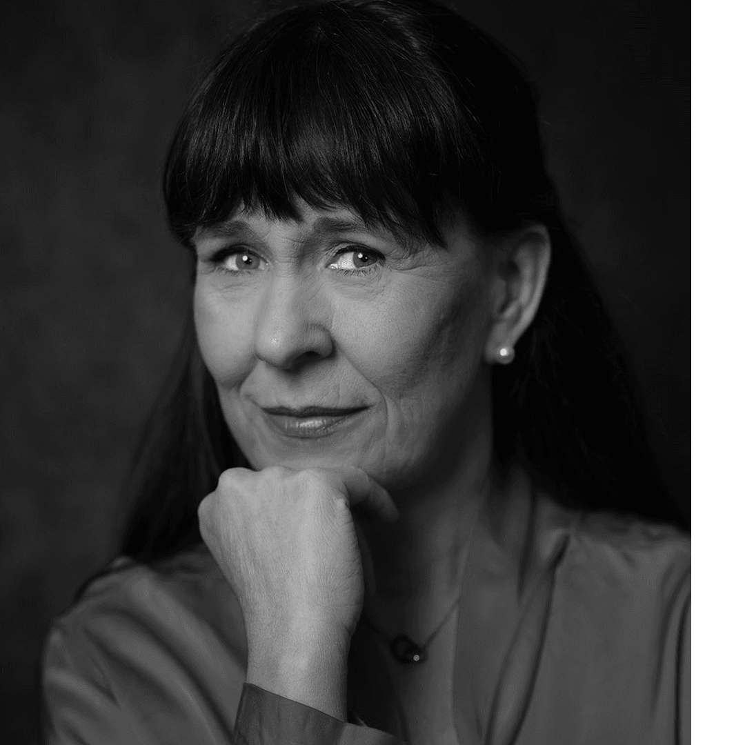 Kvinna med brunt hår och lugg, röd tröja och halsband.