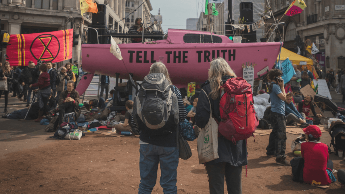 Två kvinnor står framför kris och kaos.