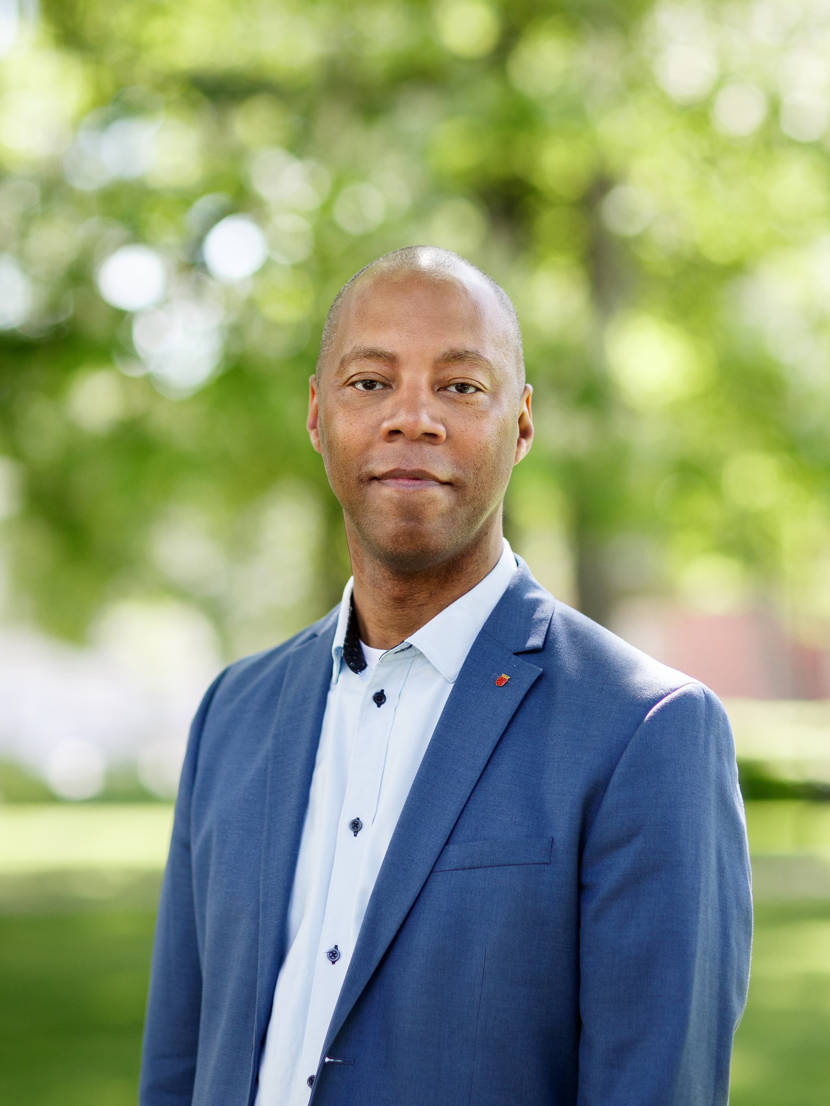 Man med vit skjorta och brun kavaj.